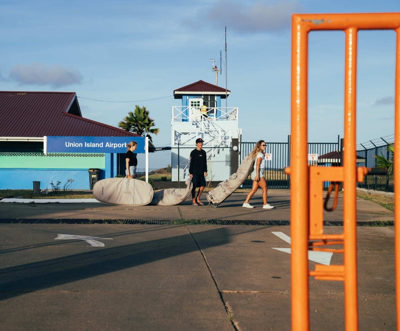 Union Island Airport terminal and travelers arriving with board bags