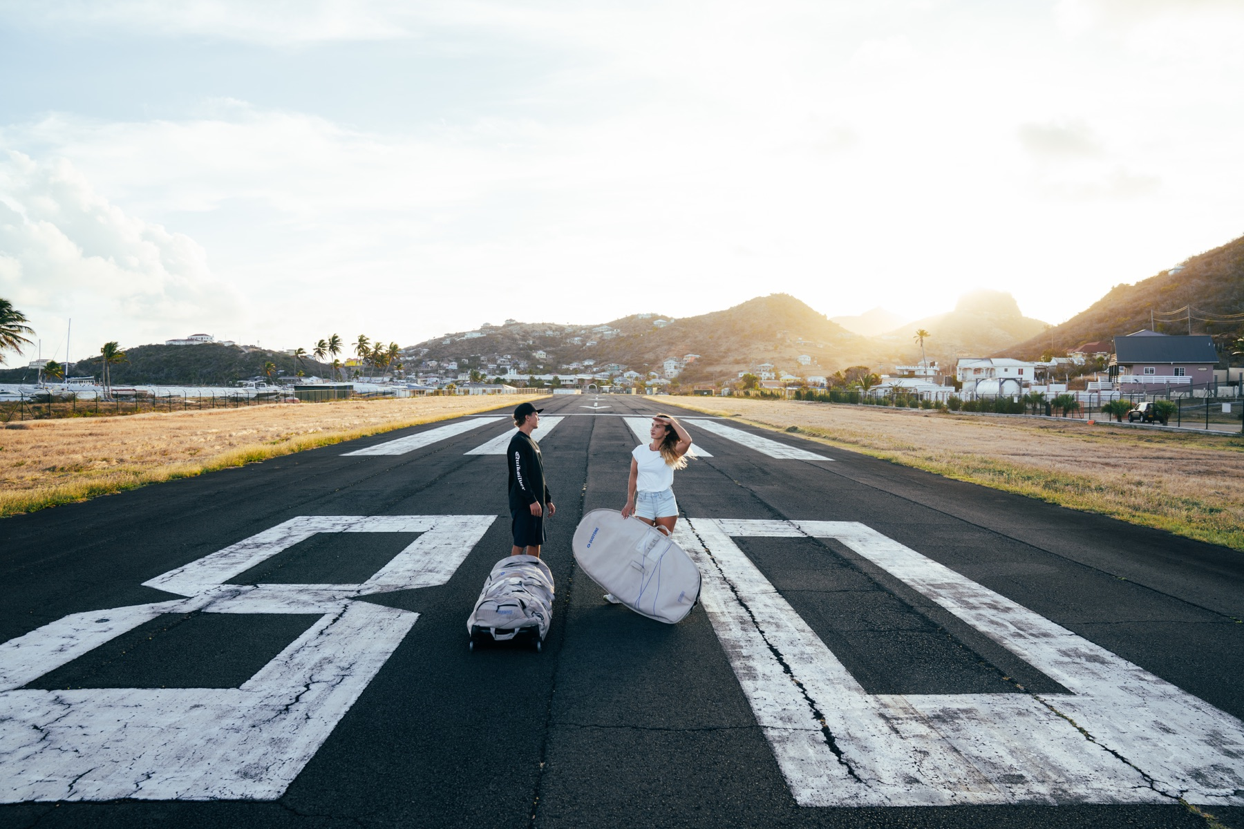 Travelers with board bags on the Union Island airport runway